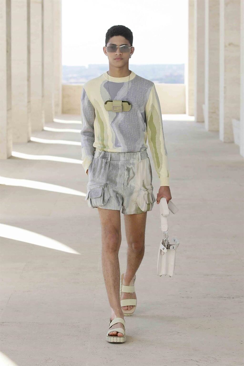 FENDI 2022年春夏男裝系列將經典包款Baguette縮小成「小廢包」，掛脖上。（FENDI提供）