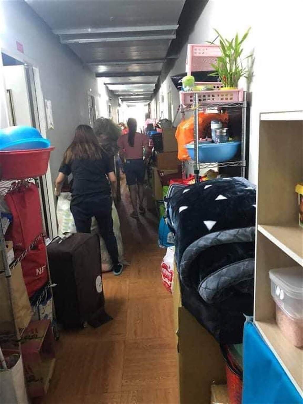 外籍移工的私人物品堆滿宿舍走廊，只剩一條小小的通道可以行走。（圖／翻攝自曾玟學臉書）。