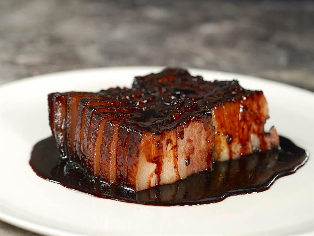 有別於傳統的紅色叉燒肉，「黑叉燒」是以五花肉取代梅頭肉，並以烤箱「暗火烤製」，口感柔軟腴嫩。（圖／蘭餐廳）