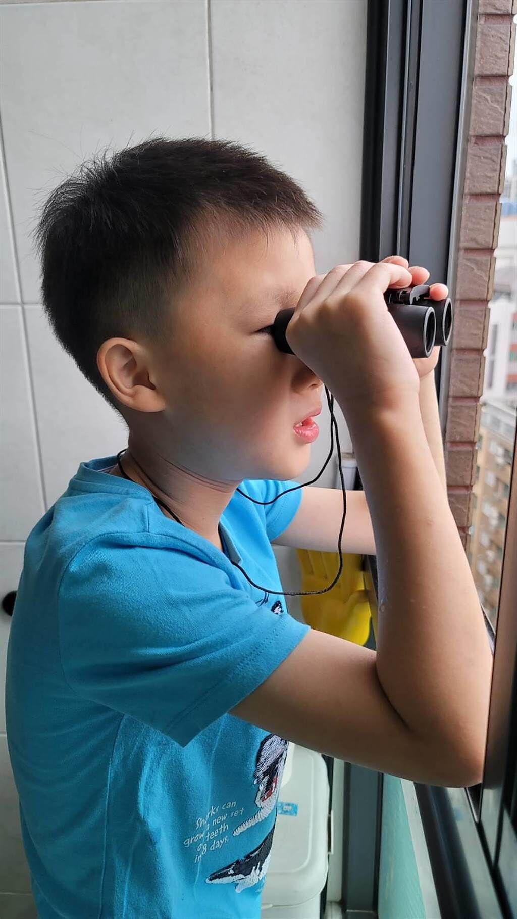 因疫情無法外出，蔣偉文送大兒子望遠鏡當生日禮物，讓他看看陽台外的景色。 （艾迪昇提供）