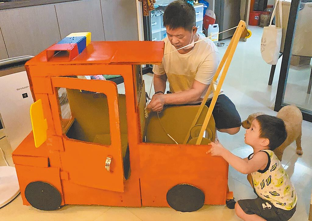 61歲的劉德仁巧手替孫子打造拖吊車、火車頭、房屋、彈珠台大型玩具。（蔡旻妤攝）