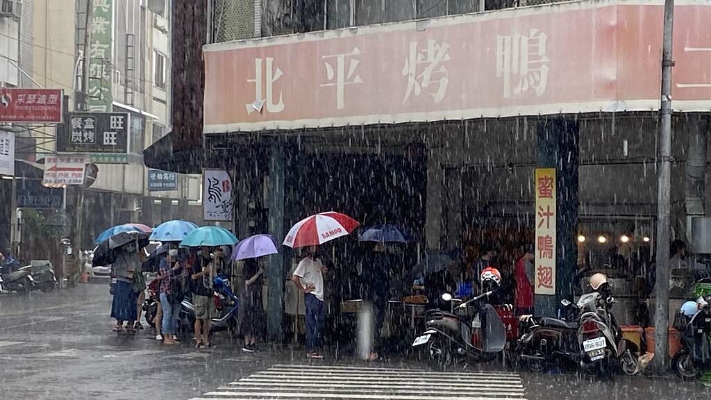 台中市向上市場的知名土窯雞，雖下雨還是見撐傘排隊人潮。（陳淑芬攝）