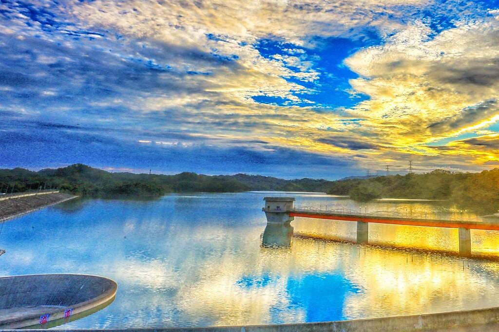 寶二水庫蓄水量近滿水位，日出雲彩倒影在水中，是新竹地區晨間美景之一。（羅浚濱攝）