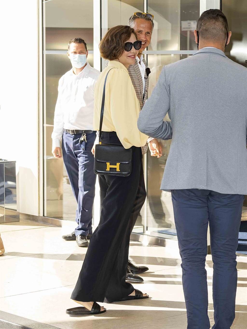 瑪姬葛倫霍以鵝黃襯衫、西裝褲，搭配愛馬仕品牌經典Constance小牛皮包，展現率性氛圍。（cfp）
