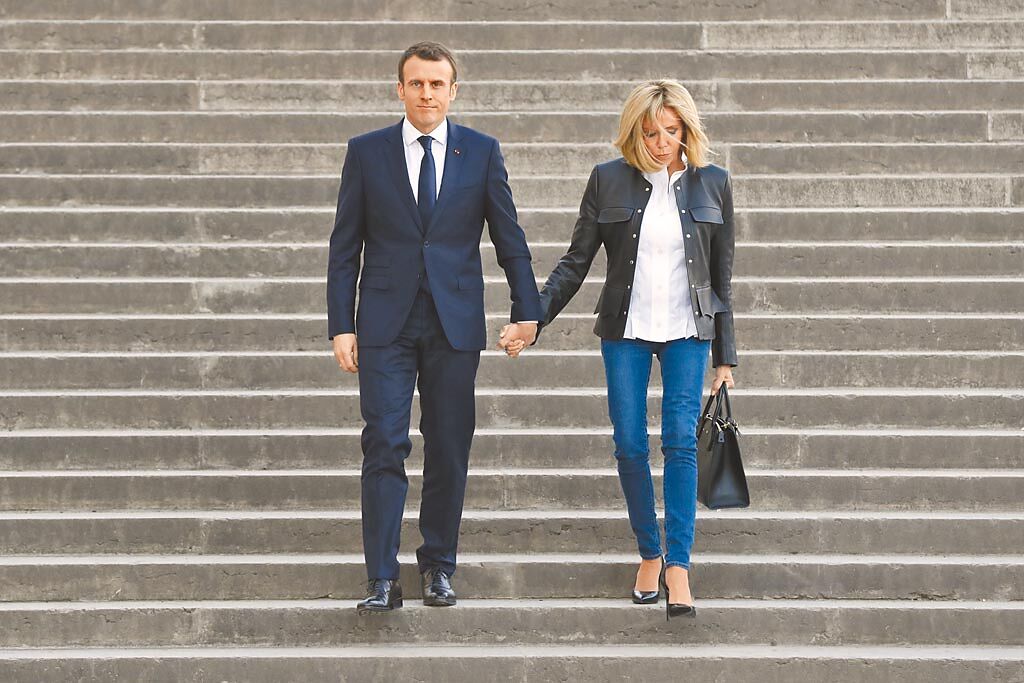 法國總統馬克宏夫人碧姬（右）出席正式場合，也以牛仔褲帥氣造型亮相。（美聯社）