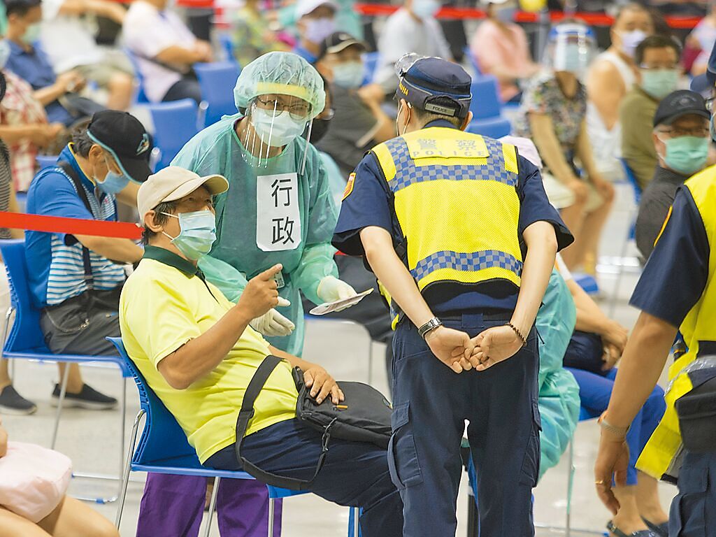 指揮中心15日宣布未來4周只能接種AZ疫苗。圖為台北市花博館接種站，民眾反映等待過久、浪費時間，服務人員與警察上前關切。（杜宜諳攝）