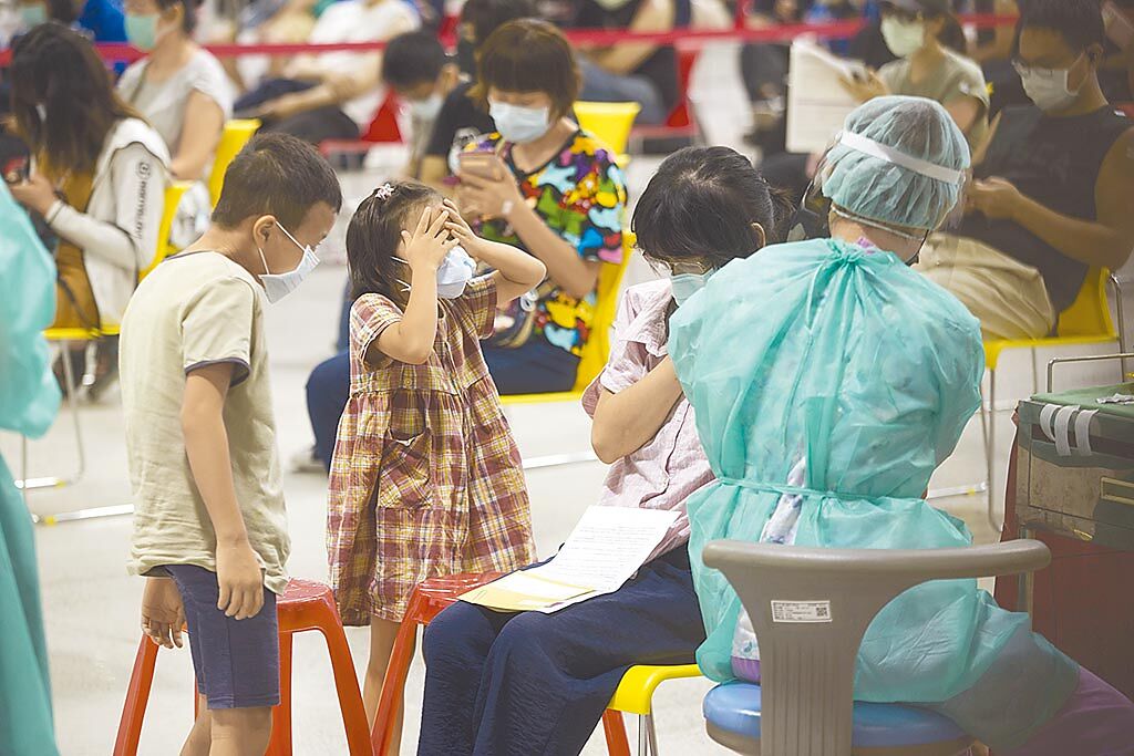 台北市開放國小教職員工等1.8萬人接種新冠肺炎疫苗，20日有接種民眾帶著孩子，小女孩看到針筒害怕到摀起雙眼，小男孩則好奇看著施打過程。（杜宜諳攝）