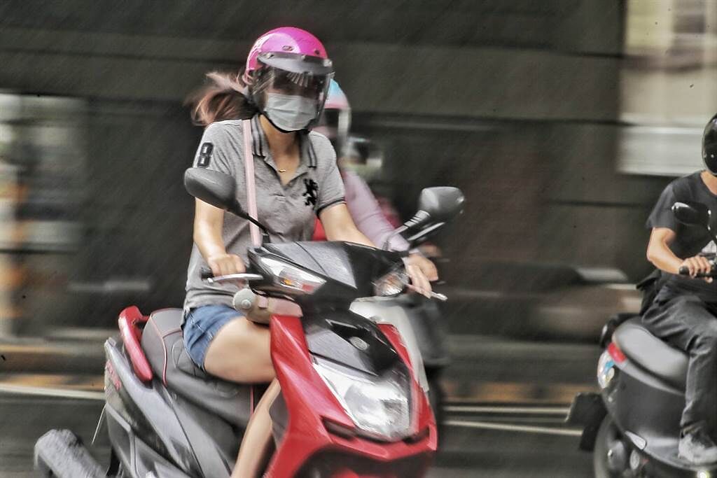 颱風環流帶來驟雨，民眾騎車來不及躲。（杜宜諳攝）