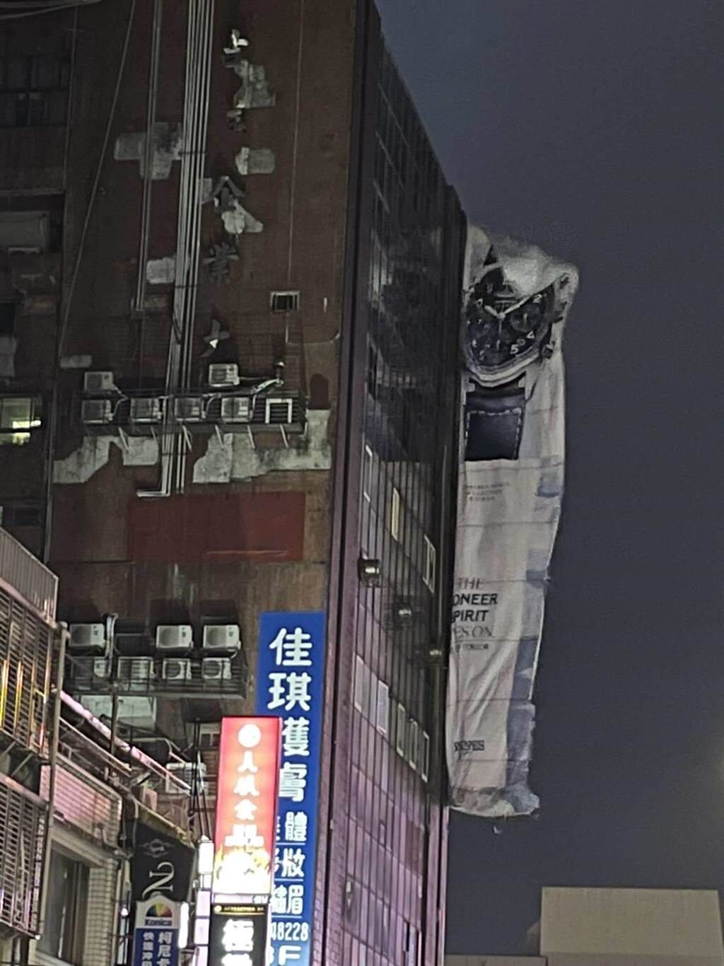 仁愛區愛三路吉祥大樓的巨型廣告帆布遭風吹落一半。（翻攝照片／陳彩玲基隆傳真）