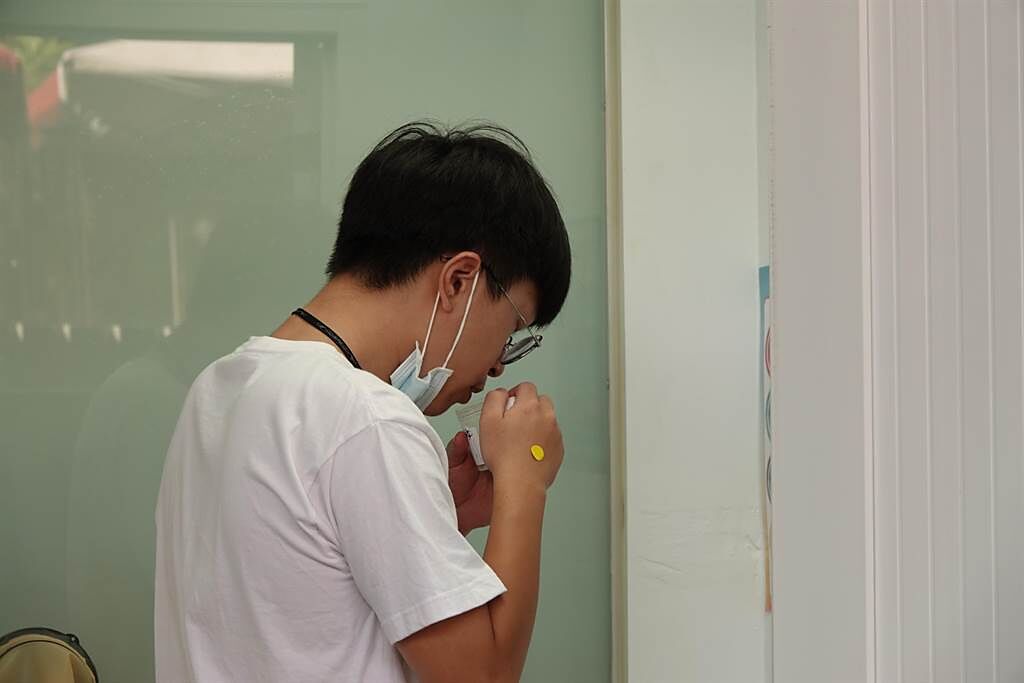 學生個別在採檢室自行將唾液滴入唾液盒。(成大提供／曹婷婷台南傳真)