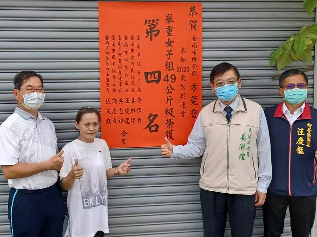 台南市副祕書長王揚智（左）等人到方莞靈家中貼紅榜。（張毓翎攝）
