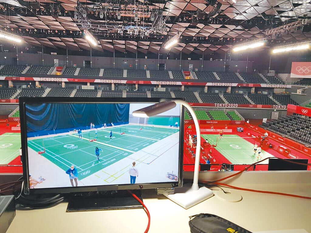東京奧運羽球場記者席，桌上有螢幕播放場上賽事。（陳筱琳攝）