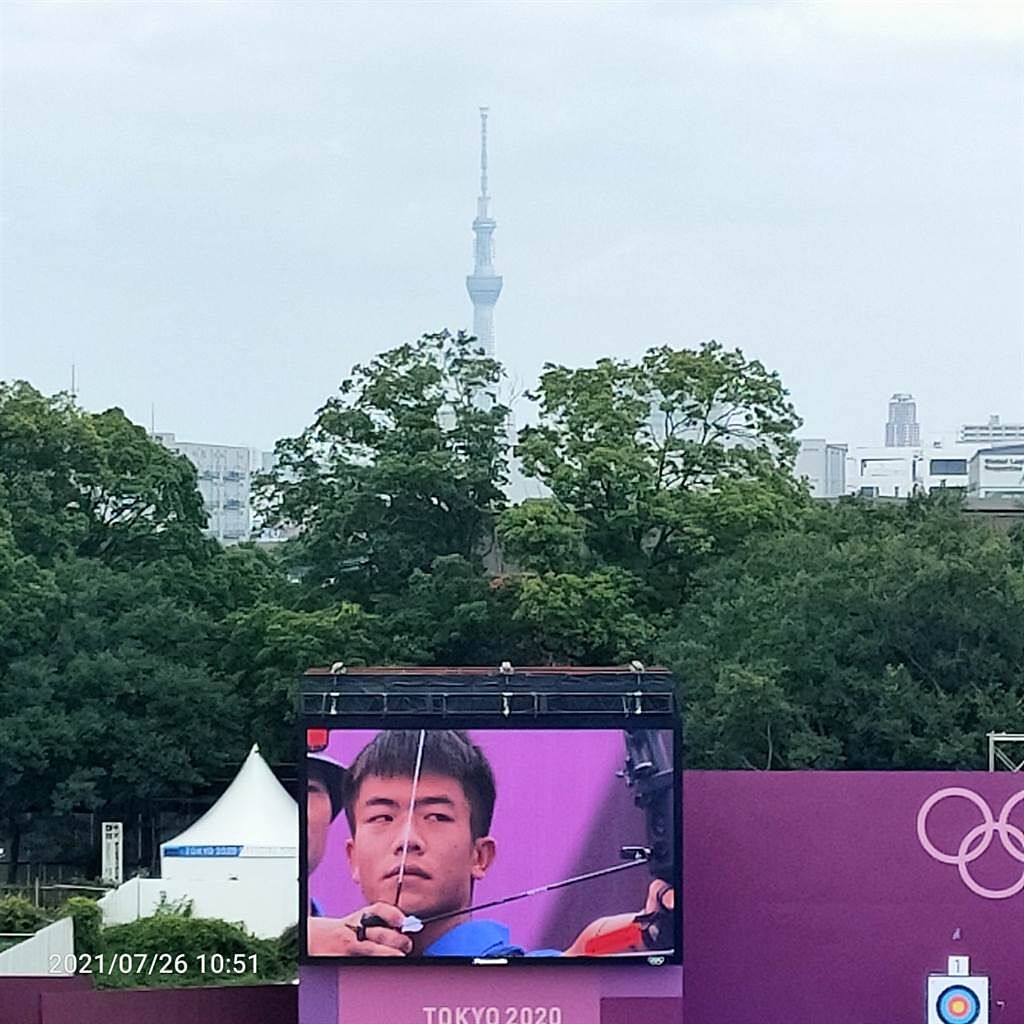 中華射箭隊團體賽擊敗澳洲，順利晉級8強，首度站上奧運殿堂的鄧宇成專注射箭，前方就是東京最著名的東京鐵塔。(黃邱倫攝)