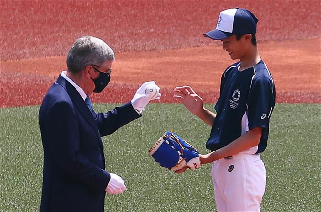 東京奧運棒球開打，賽前開球儀式由國際奧會主席巴赫將球交給日本國中球員。（路透）