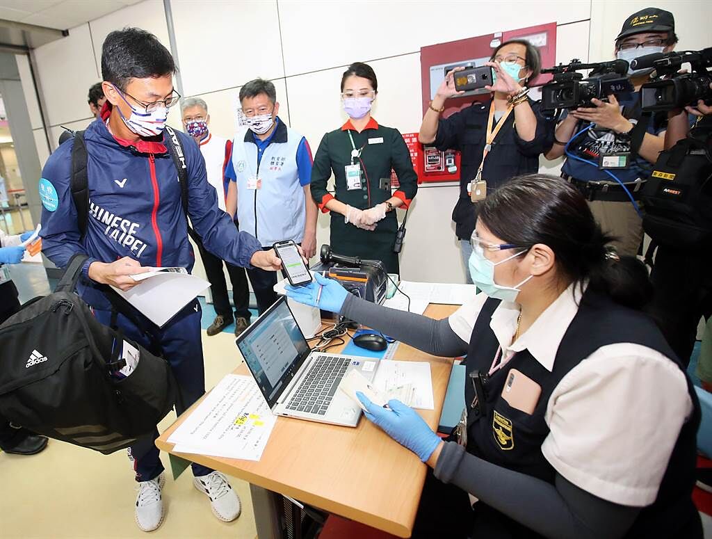 盧彥勳（左）搭機返台，入境前依照防疫規定查驗健康資料。（范揚光攝）
