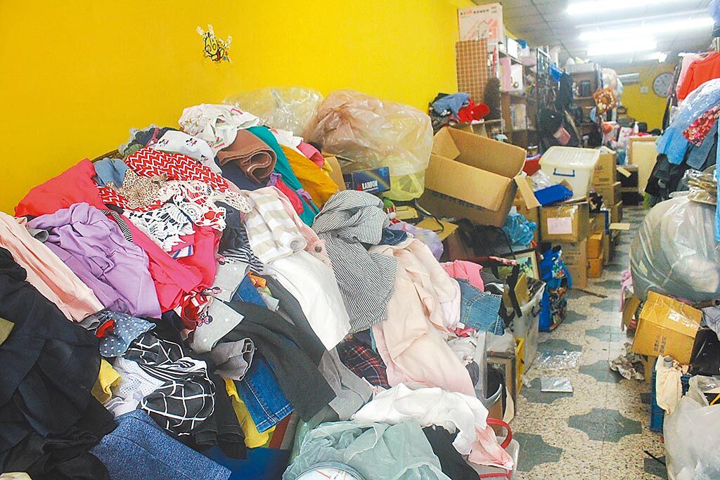 國內27日降級解封後，民眾陸續前往義賣機構捐贈衣物，機構內更因突然大量的捐贈導致衣物堆積如山。（蕭靈璽攝）