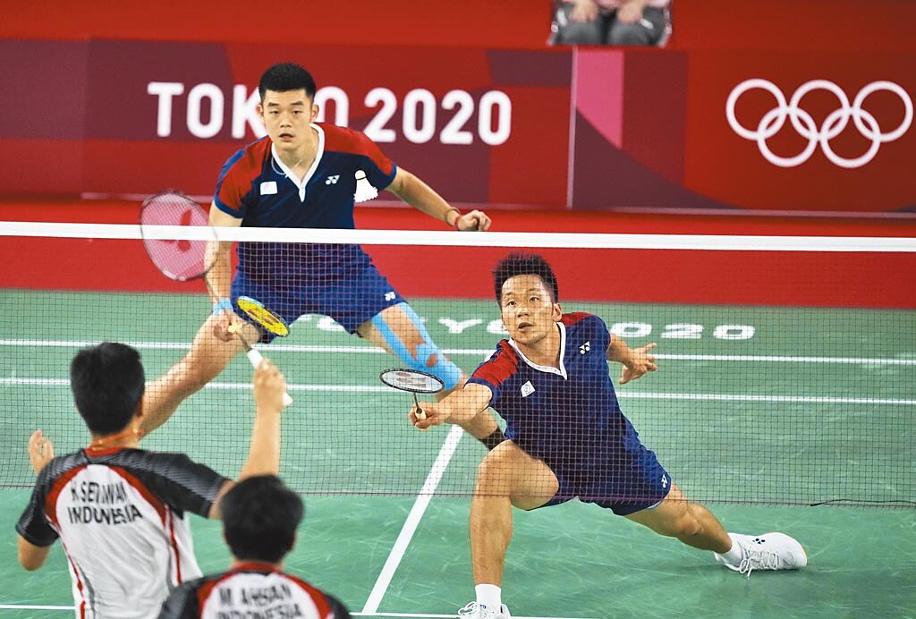 中華羽球隊李洋（右）與王齊麟（左）昨在東京奧運羽球男雙4強賽中，以不到半小時時間，直落二擊敗印尼「大賽魔王」組合，闖進今晚的金牌戰。（美聯社）