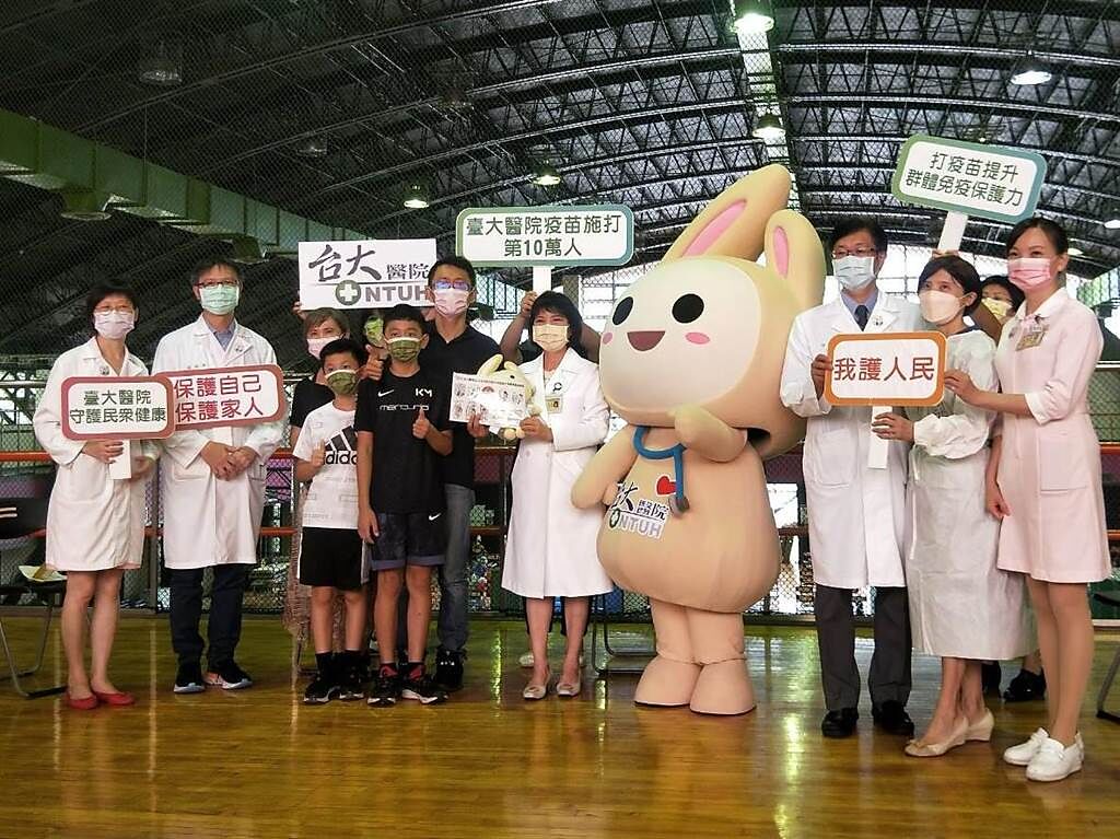 台大醫院第10萬名接種民眾誕生，徐先生開心與醫護團隊合影留念。（王家瑜攝影）