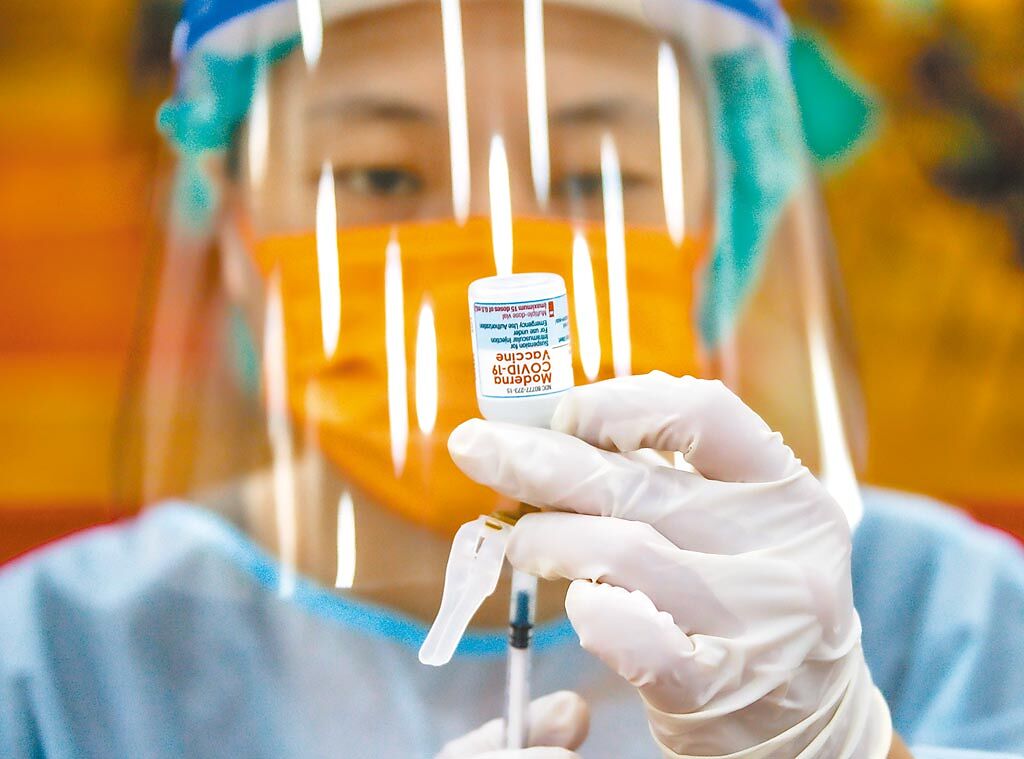 台北市7日開放居家托育人員及托嬰機構工作人員前往懷生國中體育館等地接種莫德納疫苗，為解封後復課做準備，醫護人員小心翼翼的為疫苗施打做前置工作。(羅永銘攝)