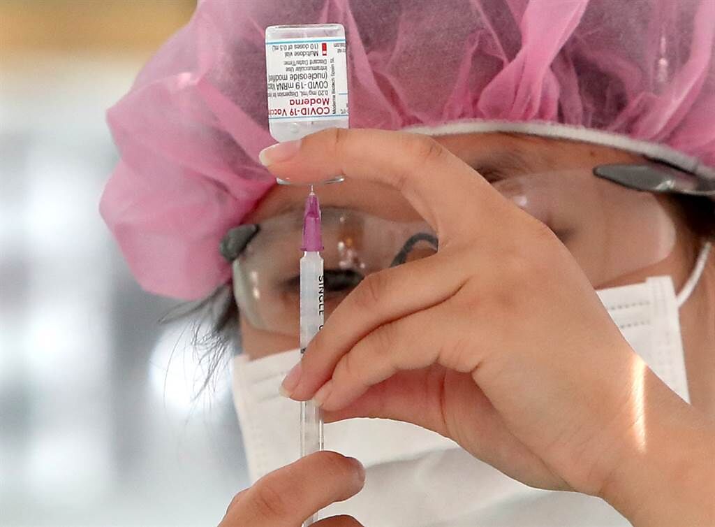 新冠肺炎疫苗第五輪預約接種11日起開始接種。接種對象包括已施打過第一劑莫德納的第一至三類對象及孕婦，及登記意願接種莫德納疫苗的65歲以上長者、55歲以上的第九類對象，共計45.1萬人。北市新光醫院在科教館的疫苗接種站11日醫護人員以針劑抽取莫德納疫苗，開始為預約的民眾施打。（鄭任南攝）