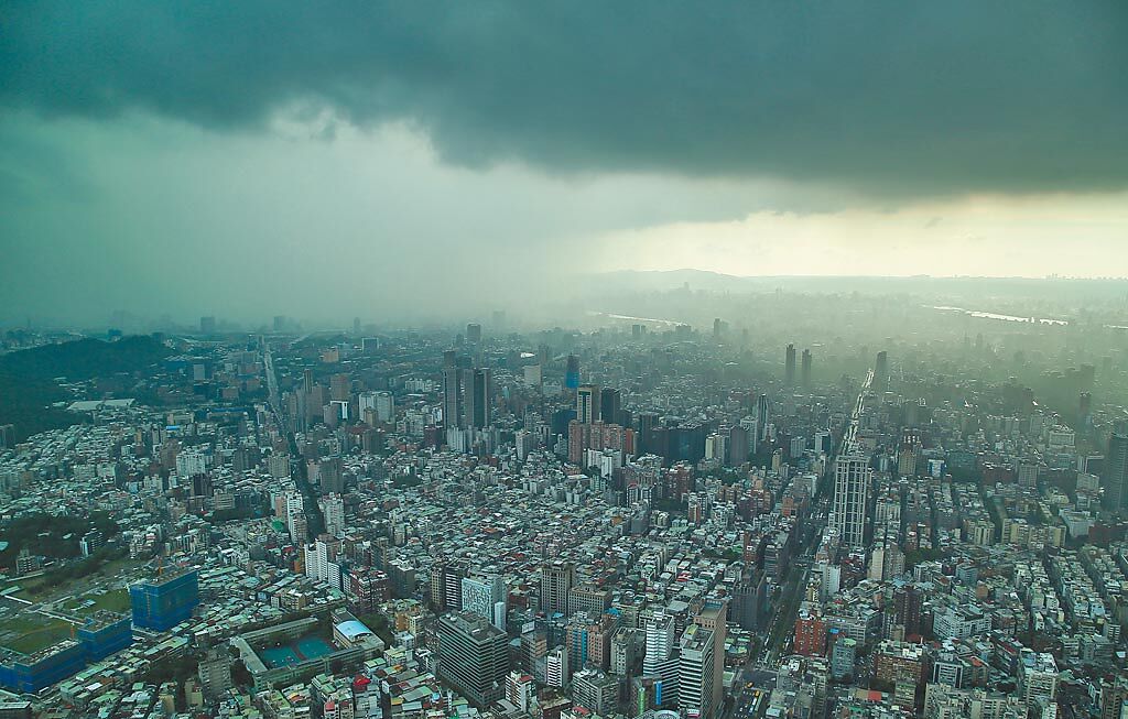 受到西南氣流影響，台北市天氣變化劇烈，11日上午烈日高照，午後出現局部大雷雨，圖為從101大樓鳥瞰下著大雷雨的台北。（陳俊吉攝）