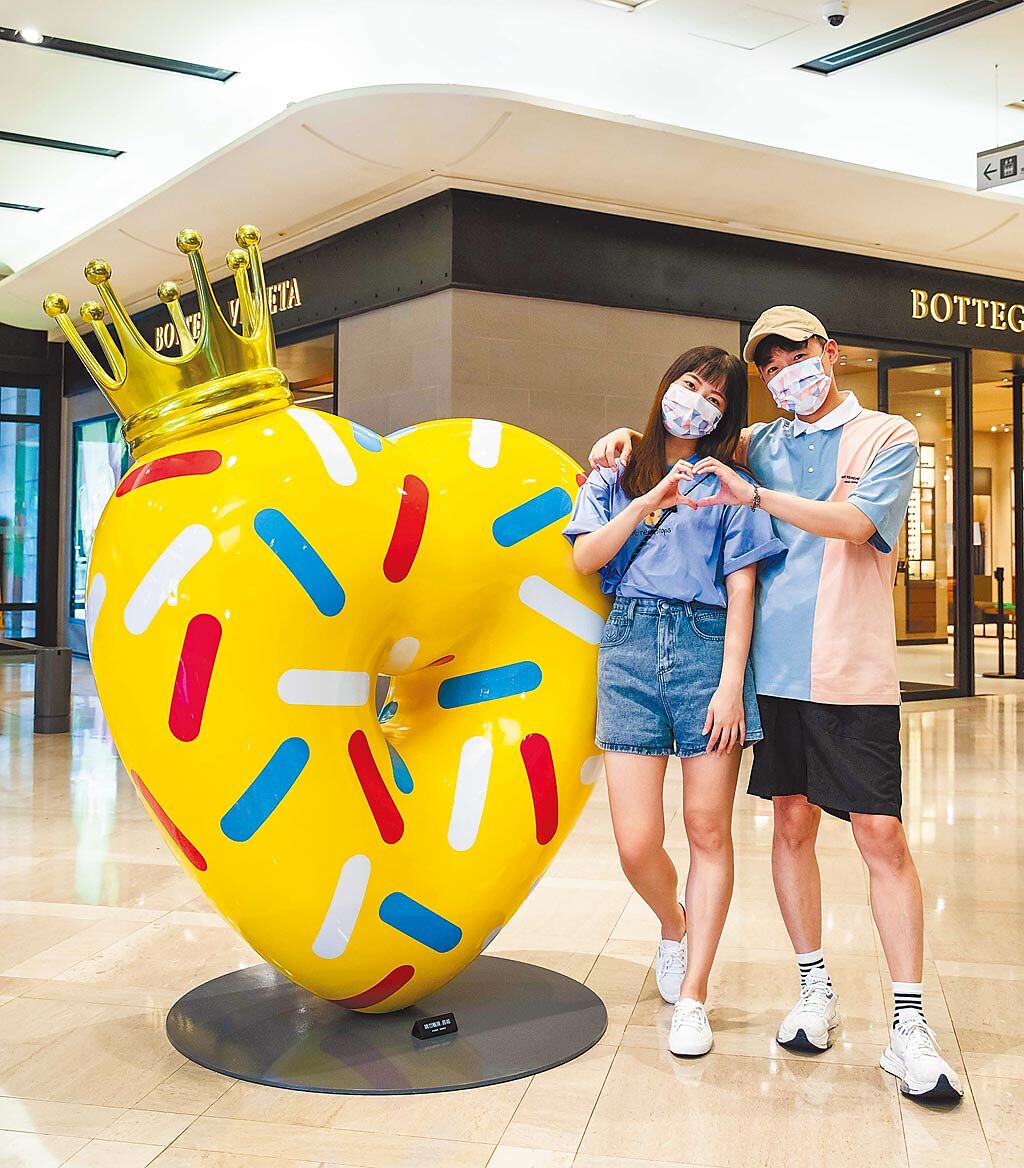 與情人在「皇冠甜甜圈」幸福感立現，新光三越台北信義新天地是亮黃色（見圖）、台中中港店是桃色、台南新天地是粉紫色。（石智中攝）
