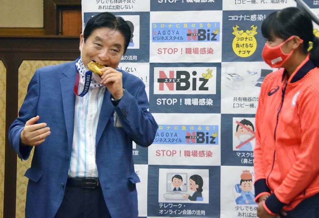 名古屋市長河村隆之(左)當眾嚙咬國手的金牌，遭到大量市民投訴。（美聯社／kyodo news）