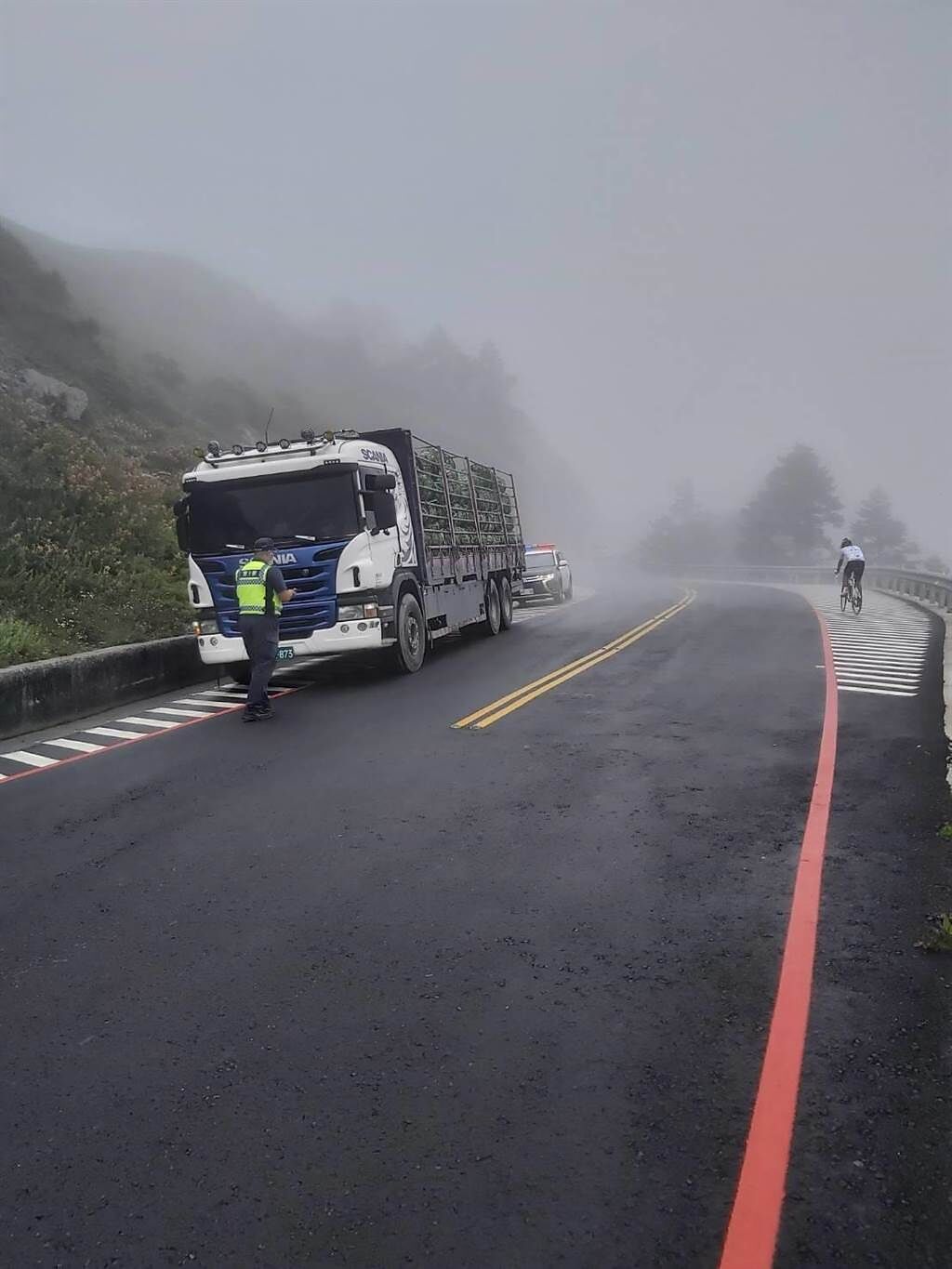 合歡山武嶺地區14日一早下小雨還起霧，警方到場維持交通，也取締未戴口罩及防疫宣導。（民眾提供／盧金足南投傳真）