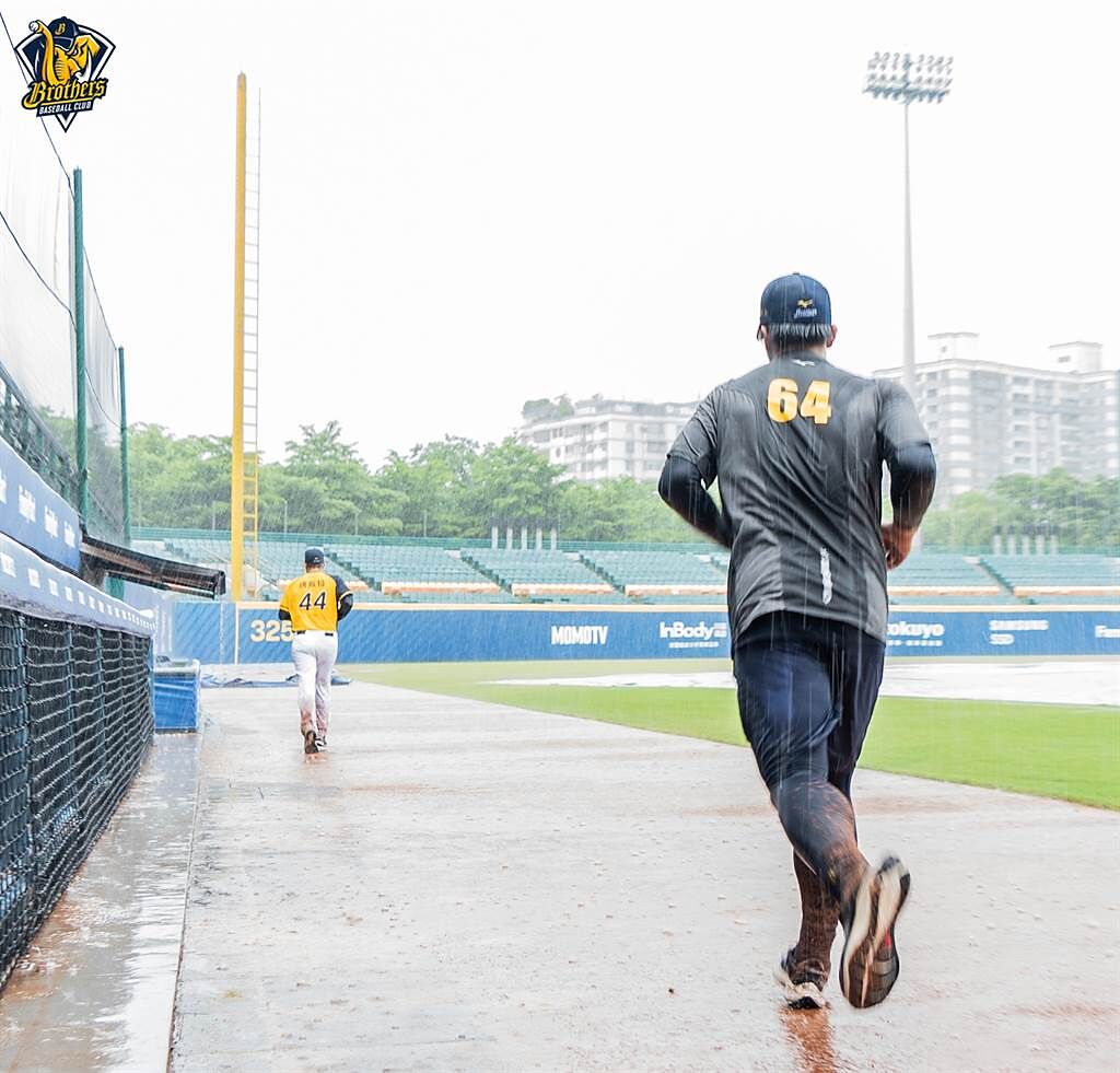 中信兄弟黃恩賜賽前與投手教練佛斯特一起在雨中慢跑。（中信兄弟提供）