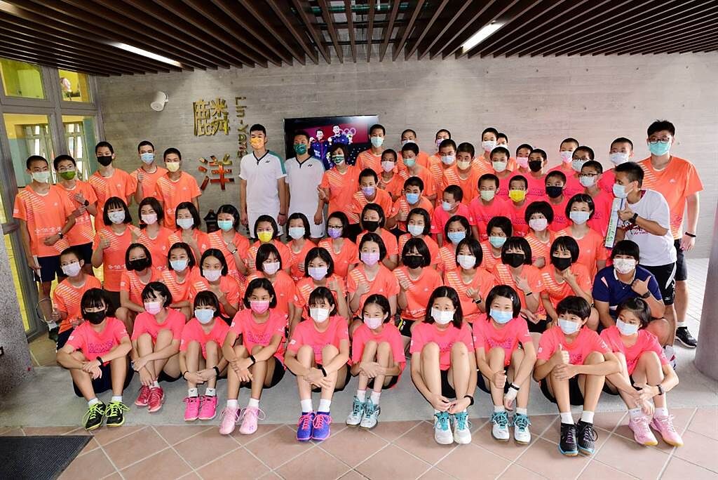 李洋(最後排左7)、王齊麟(最後排左6)回到母校中山國中，捐贈205打羽球給學弟妹使用。(北極熊羽球提供)