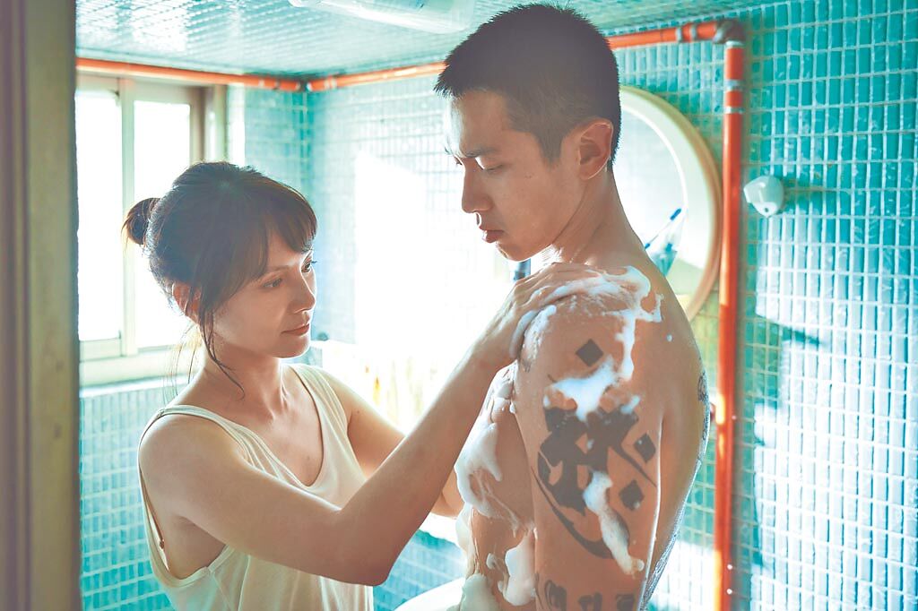 李心潔（左）在《鱷魚》中幫受傷的柯震東洗澡。（台北双喜電影提供）