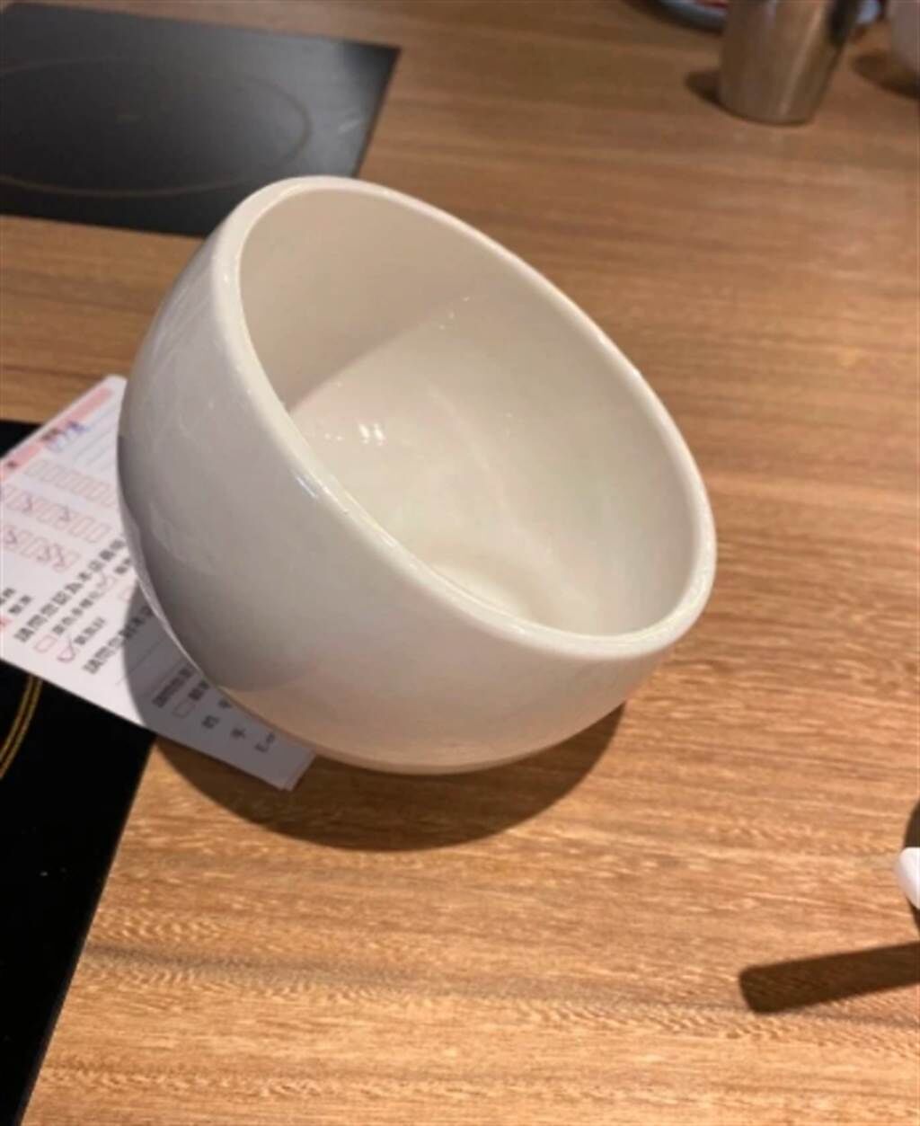 一位網友近日到火鍋店用餐，發現桌上擺著一個謎樣小白碗，不知道拿來裝什麼。對此，火鍋店員工親自解釋它的真正用途。（摘自Dcard）
