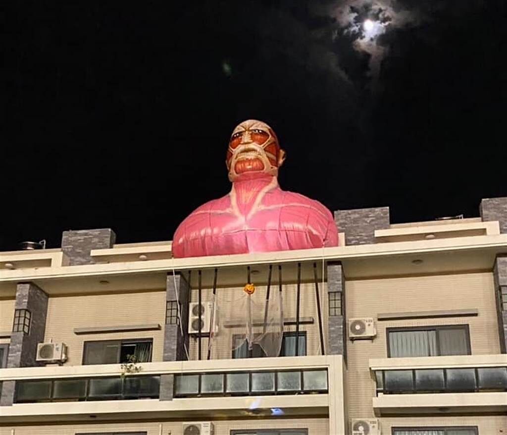 台南市新營一處民宅屋頂出現動漫「進擊的巨人」充氣公仔，夜晚還有打燈。（圖／翻攝自臉書 爆廢公社二館） 