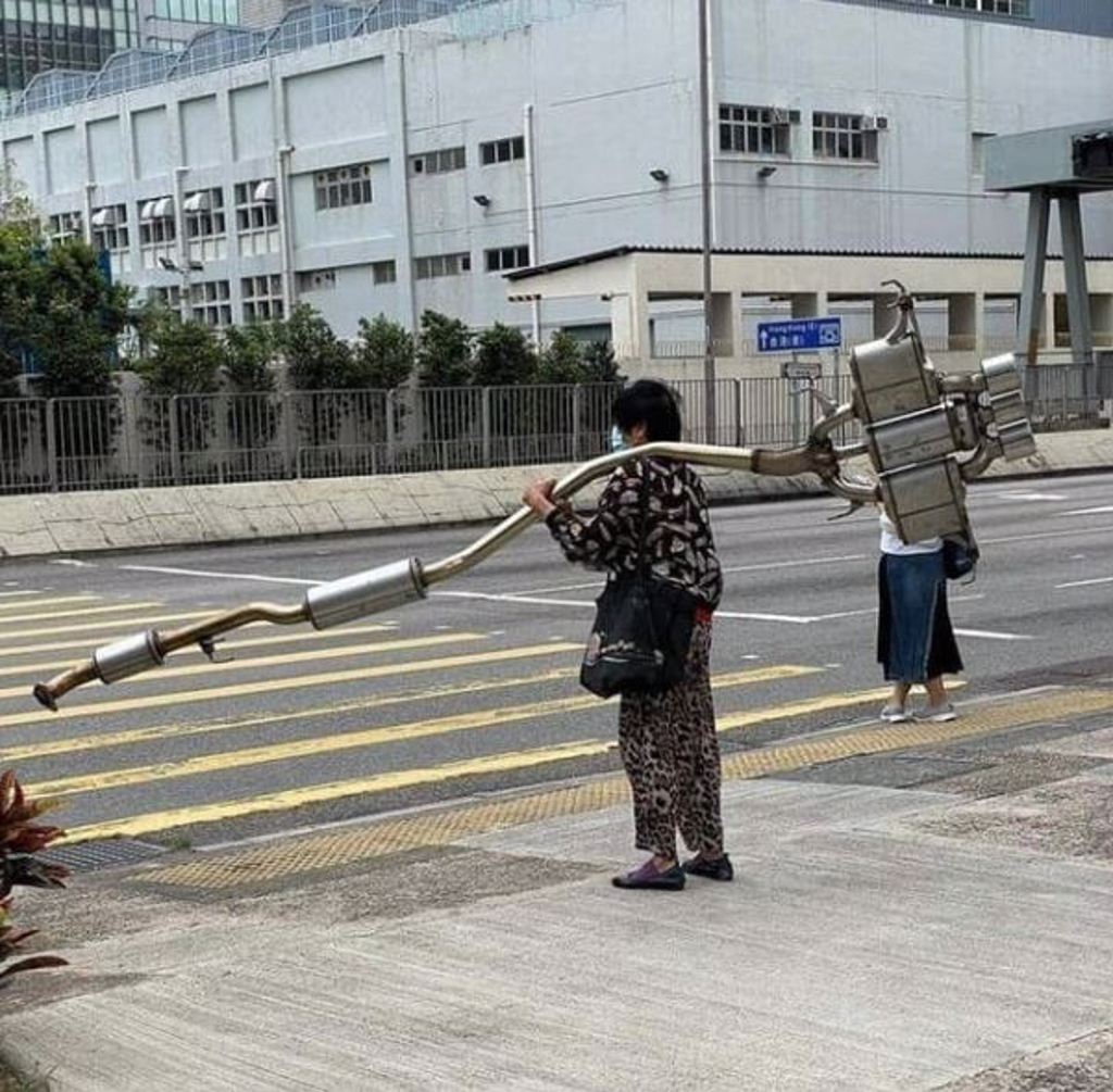 照片中婆婆力大無窮，扛著近10公斤排氣管過馬路（圖片／翻攝自香港01）