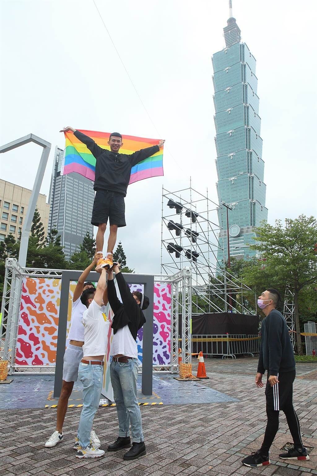 同志大遊行今年因COVID-19影響首度改為線上，主辦單位並舉辦實體活動，在台北市政府前南廣場等地方設置打卡牆，並有民眾表演啦啦隊團隊特技，手持彩虹旗合影。（張鎧乙攝）

