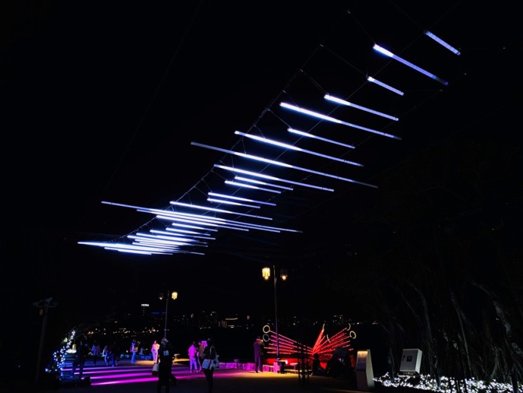 林書瑜《微浮Wave》創作，燈管排成12公尺類似音軌的波浪狀，民眾走過就會自然擺動。（淡水古蹟博物館提供）`