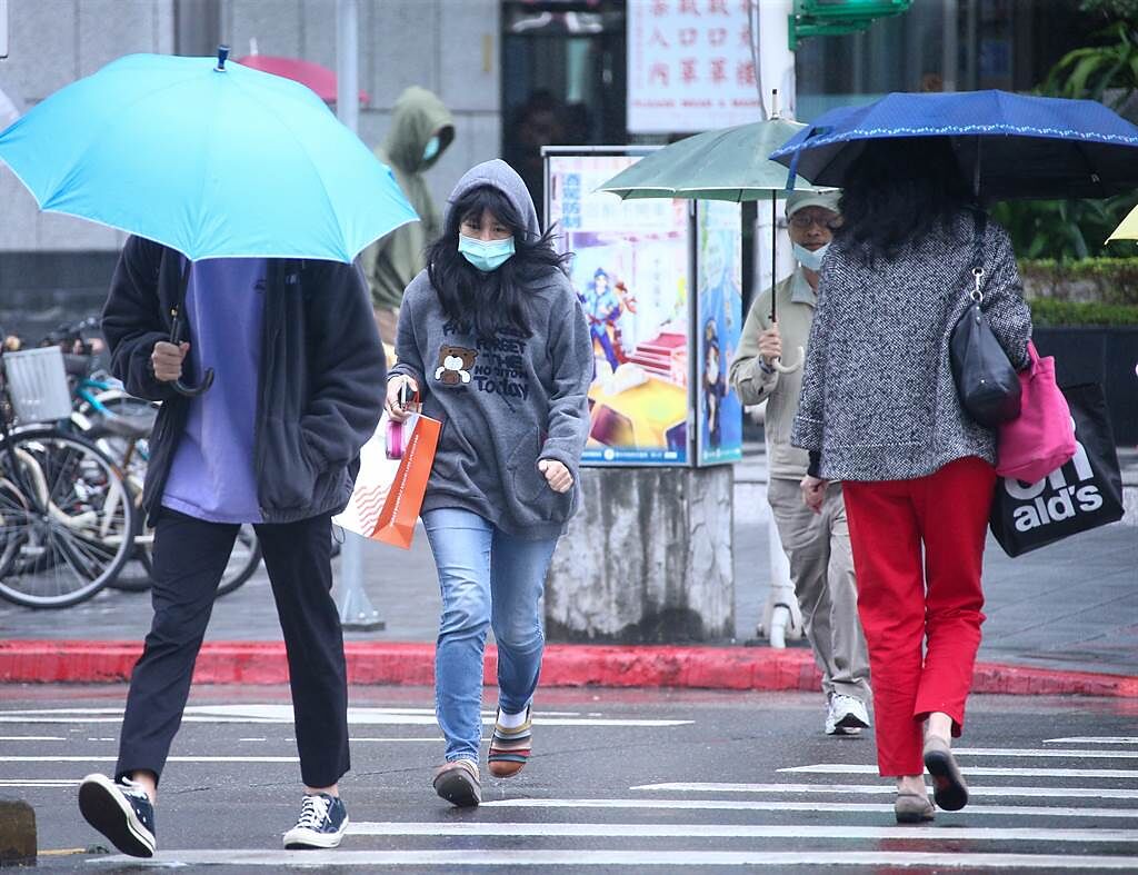 入冬最強冷空氣將在25日南下台灣，一路冷到28日，全台連凍4天。台北市24日白天有局部短暫雨，民眾上街紛紛撐起雨傘避雨。（羅永銘攝）