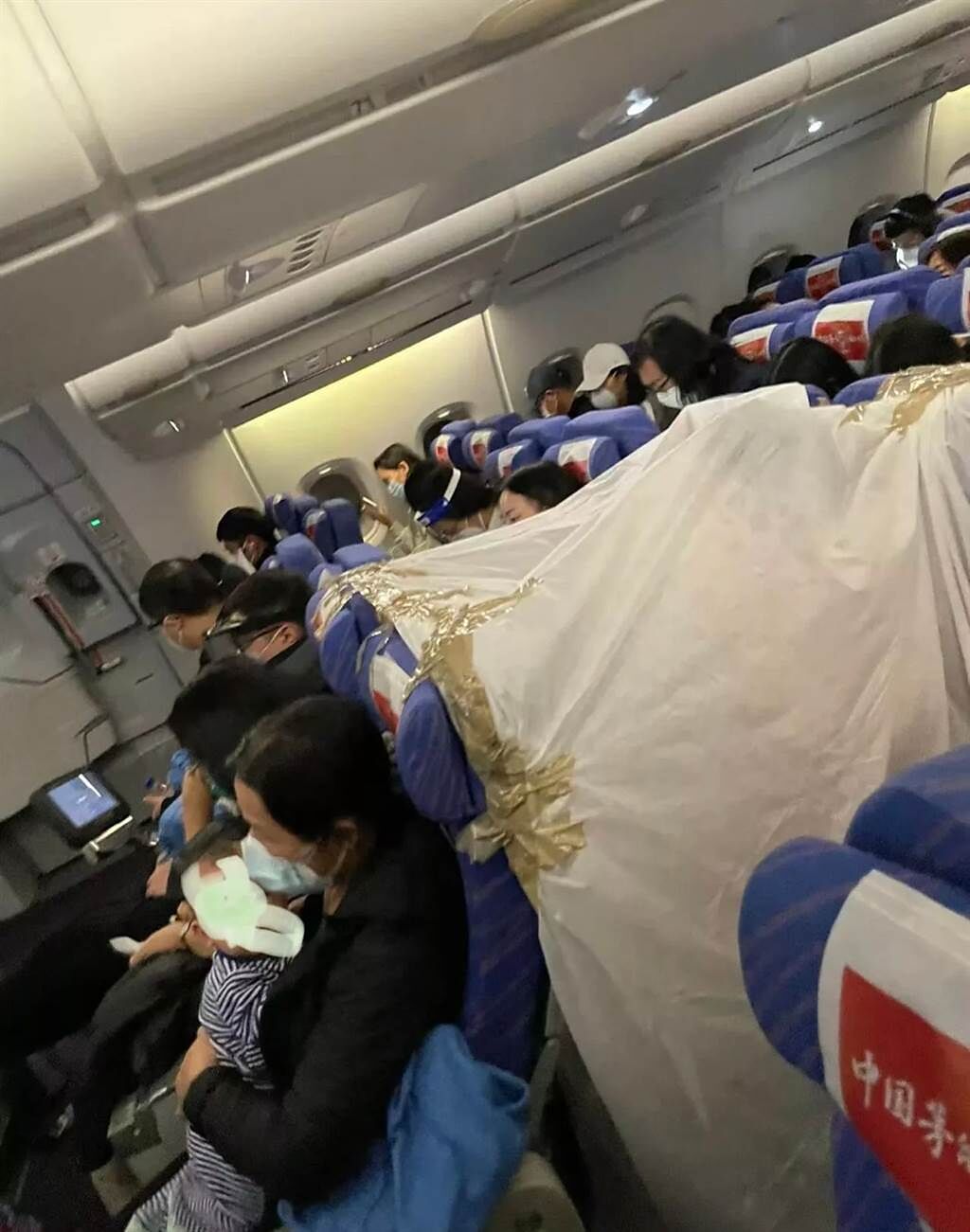 一名大陸網友分享，飛機上有一名男乘客為了防疫，直接再飛機上搭起帳篷保護自己，讓他相當驚訝。（圖／翻攝自微博）