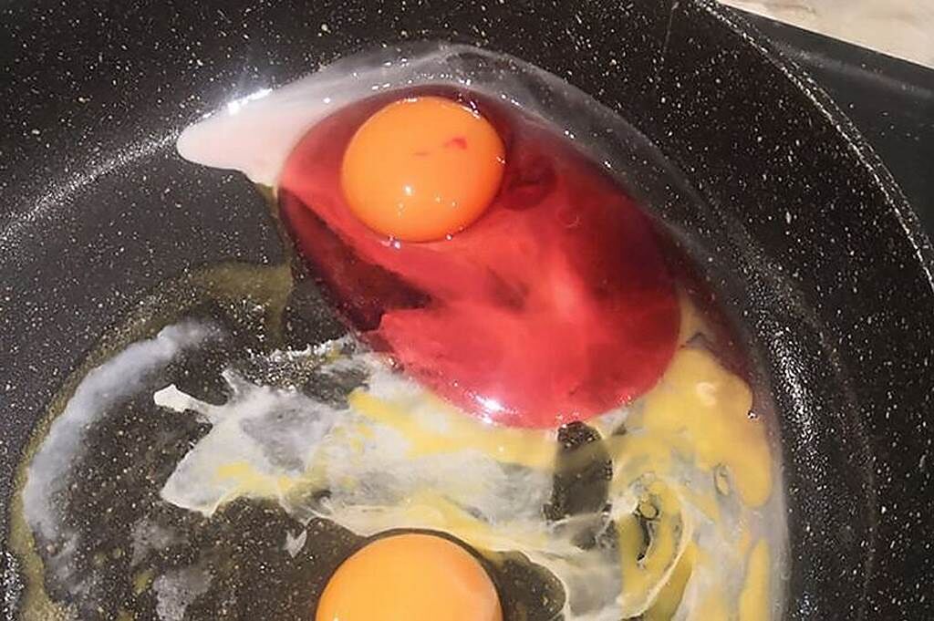 英國一名女子日前煎蛋時，意外發現一顆擁有「草莓蛋白」的詭異生雞蛋。（圖片翻攝自FB/Henzyworld）