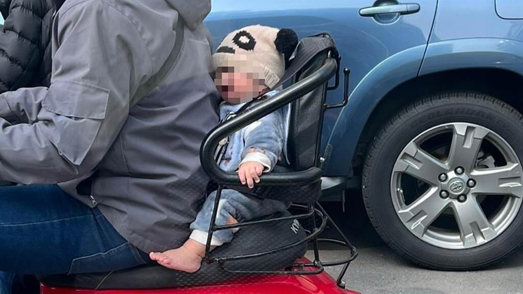 有民眾目擊1名父親在機車後座放上嬰兒座椅，載著小嬰兒上路，並用背部緊緊將嬰兒擠在座位內，這1幕讓網友痛批太危險。（翻攝自臉書「爆廢公社」）