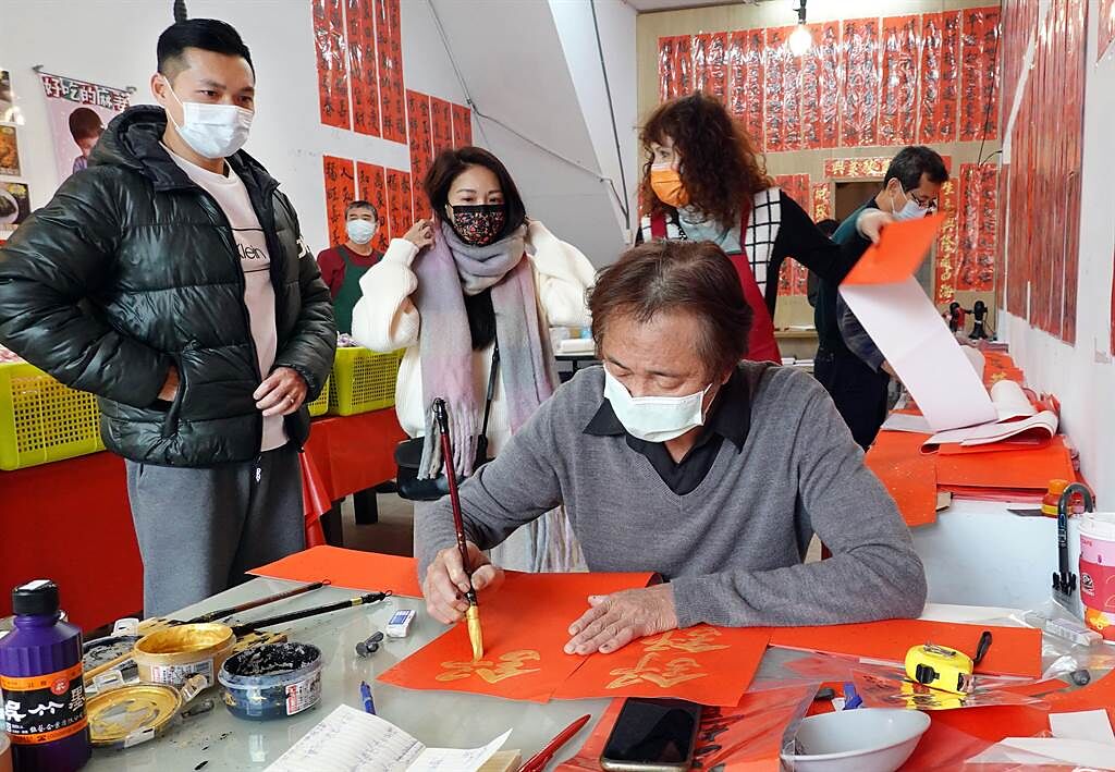 「台北市年貨大街」迪化街裏，賣春聯的商家請來書法老師當場揮毫。（姚志平攝）