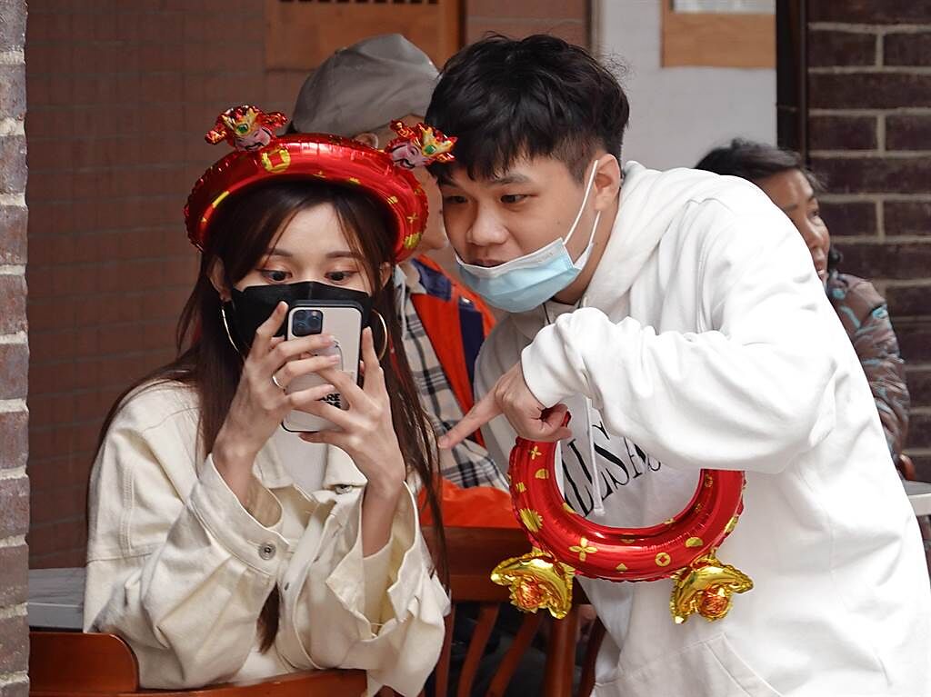 「台北市年貨大街」迪化街裏，民眾戴起喜氣頭飾拍照留念。（姚志平攝）