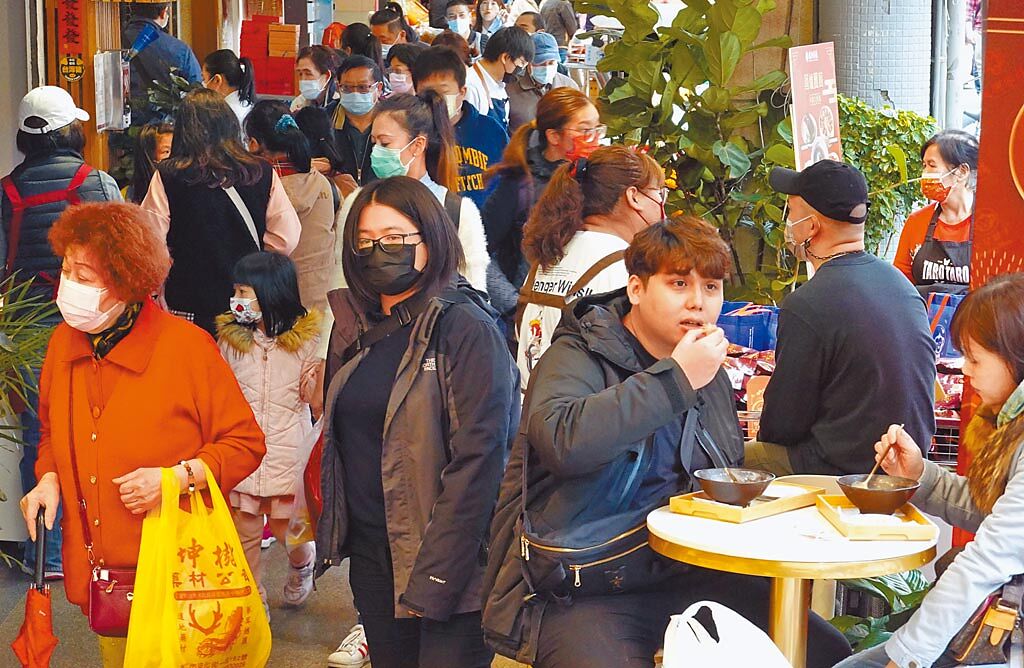 「台北市年貨大街」迪化街29日湧現搶辦年貨的人潮，但飲食攤及店家的戶外用餐區與逛街民眾毫無距離，防疫問題令人憂心。（姚志平攝）