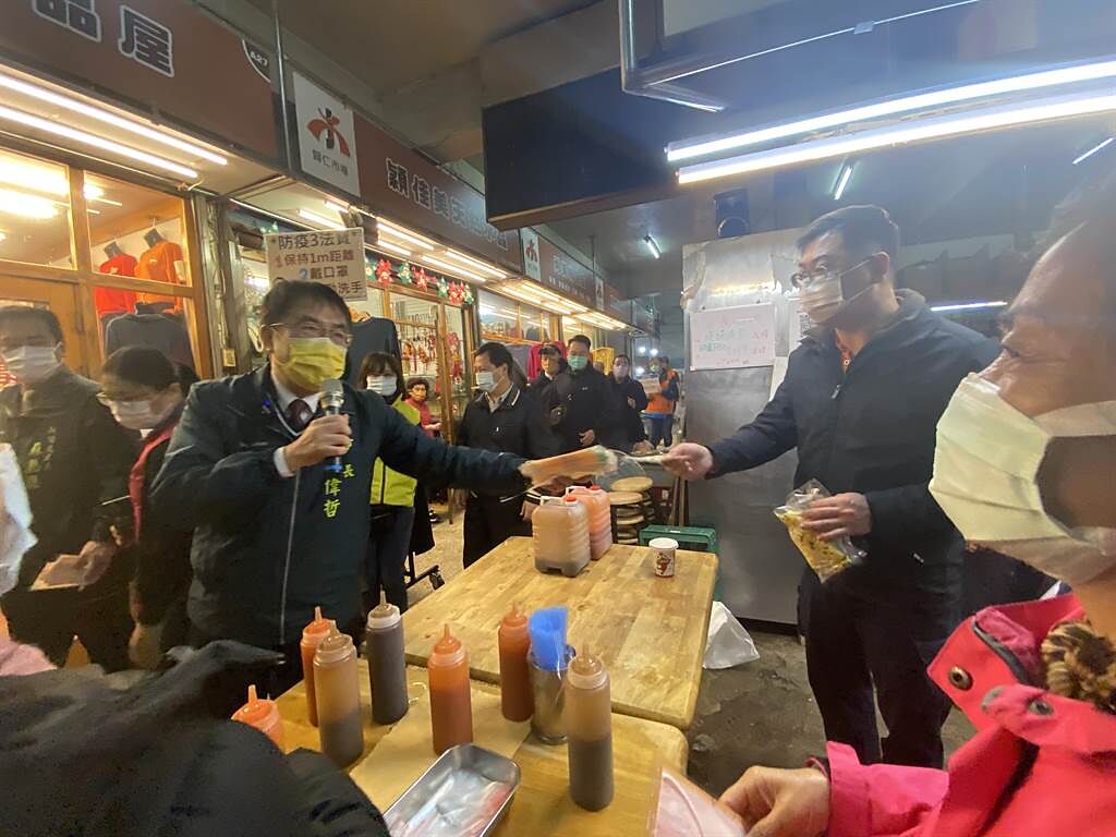 台南市長黃偉哲（左）今早視察歸仁市場防疫，沿途發放口罩也跟攤商拜年。（曹婷婷攝）