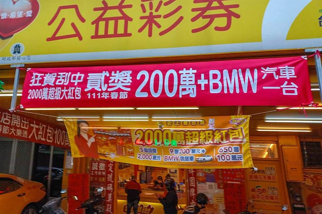 一對40多歲夫妻在竹北市財鑫彩券行，刮中首個200萬加BMW休旅車的幸運大獎，彩券行掛出紅色布條慶賀。（羅浚濱攝）