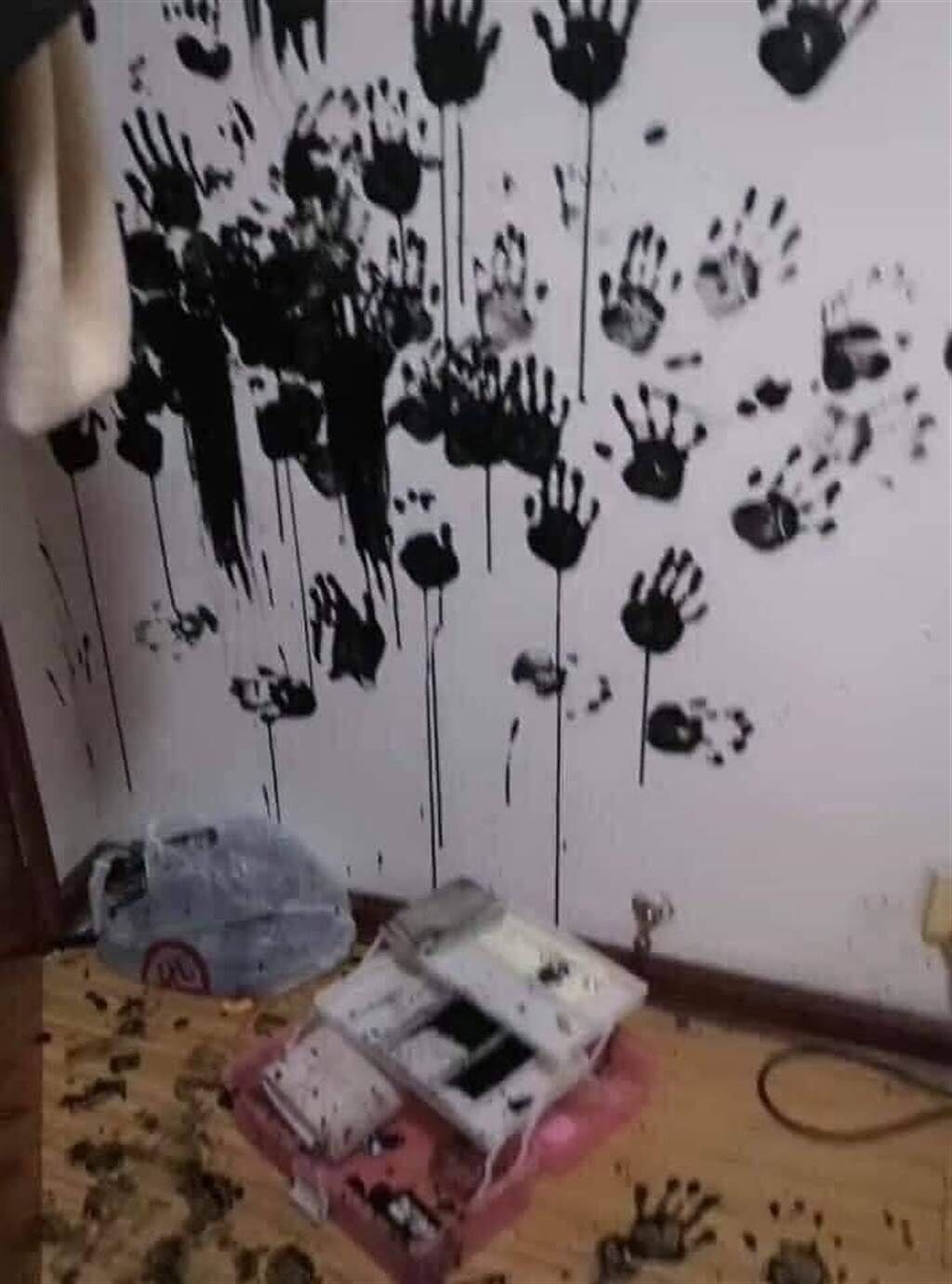 1名網友分享女兒用「黑手印」為牆壁留下的「傑作」，只見牆上密密麻麻的墨汁手印，女兒臉上、雙手也全是墨汁，事後女兒還相當酷跩地站在一旁。（翻攝自臉書「爆廢公社公開版」）