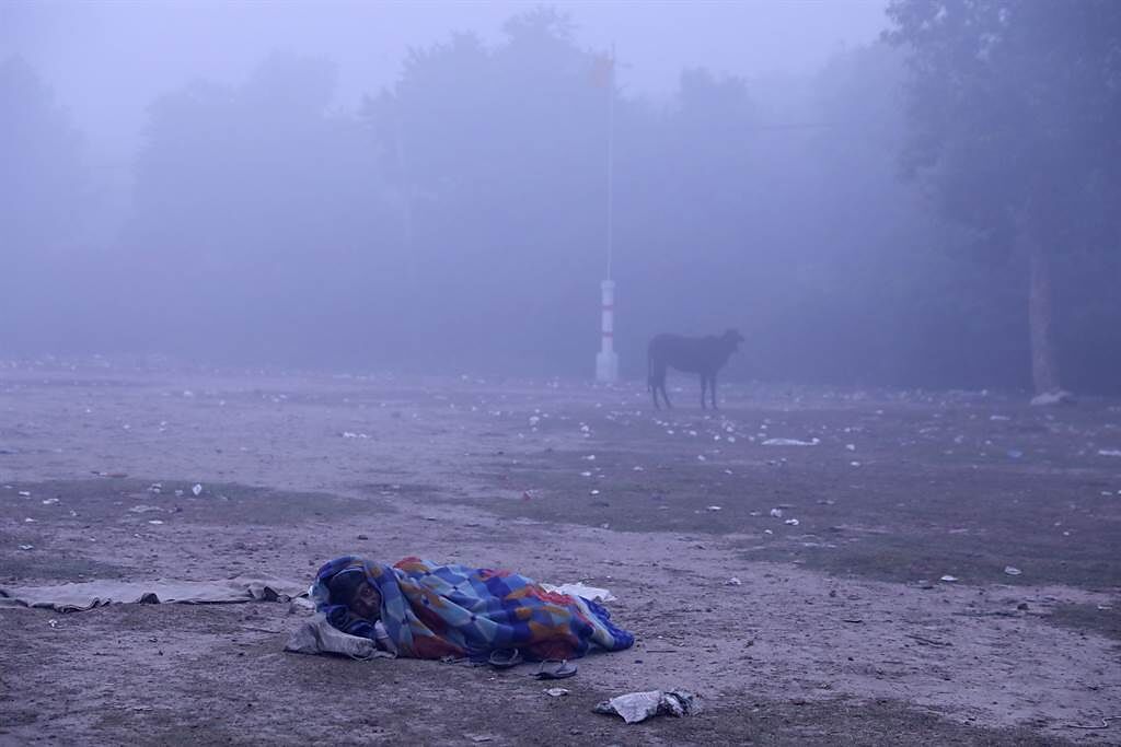 第二大城德里(Delhi)紛紛傳出街友受凍路邊沒了呼吸心跳。圖為一名街友無家可歸只能睡在路旁。(圖/路透社) 