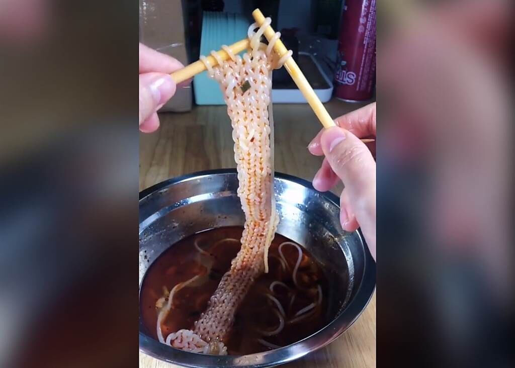 該名女網友手拿竹筷，把麵條當毛線，熟練的將泡麵串起，織出一條「迷你麵圍巾」。（圖／翻攝自Dcard）