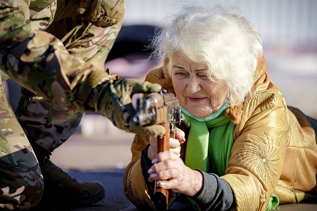 79歲阿嬤康斯坦丁諾夫斯卡（Valentina Konstantinovska）趴在地上拿起AK-47突擊步槍，準備好對抗俄羅斯士兵。（圖／美聯社）