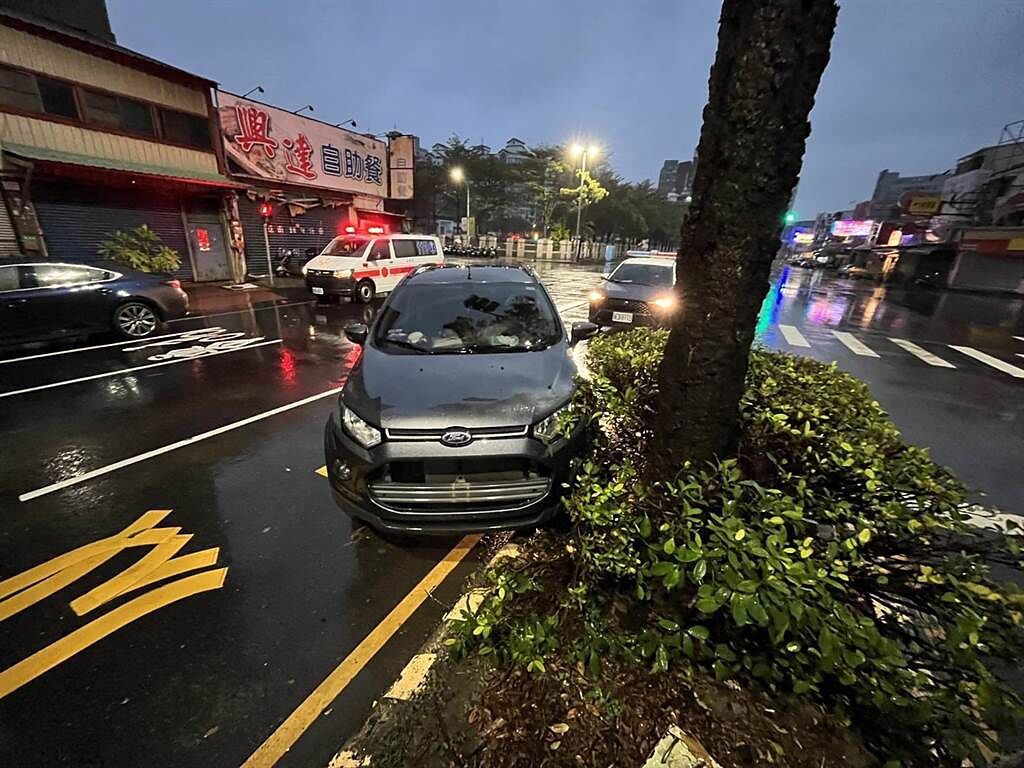 嘉義市昨天發生2輛自小客車轉彎時碰撞，其中1輛衝撞路樹卡在分隔島。（讀者提供）